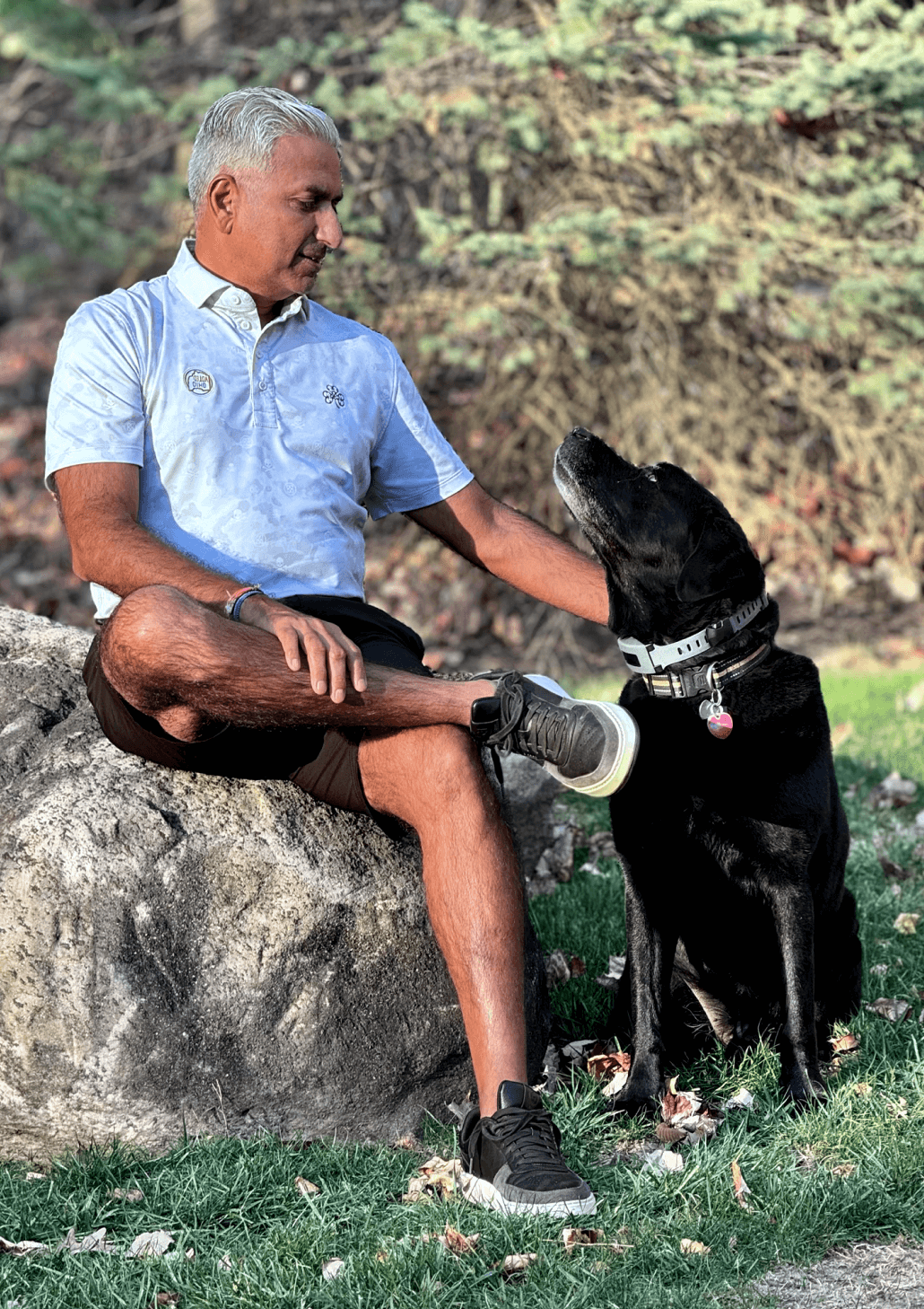 Man sitting on a rock with his dog.